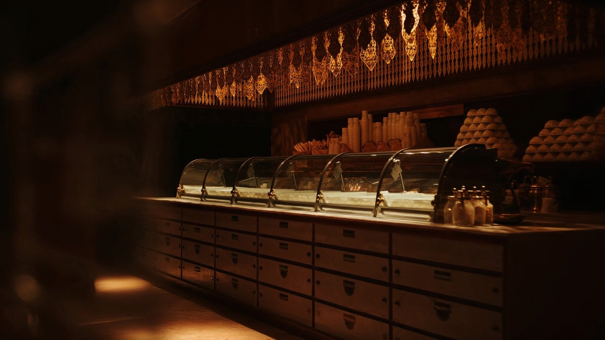 A warm bakery display case glowing at night